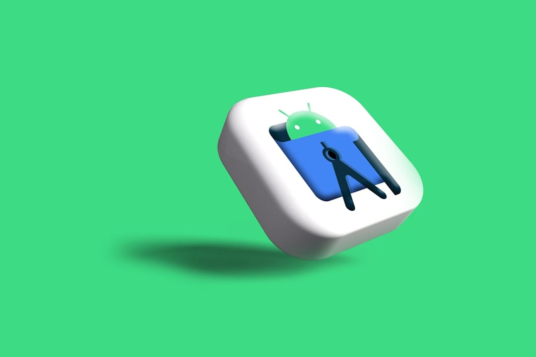 Types of Android App Development A software developer workspac e with code and mobile app mockups.